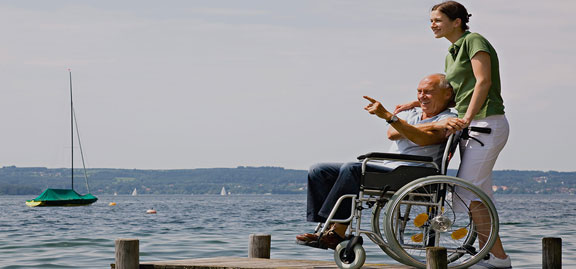 Man with wheelchair and a woman holding him